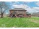 Lush backyard showcases a brick house with a deck, complete with outdoor furniture at 130 George Ct, Danville, IN 46122