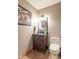Cozy powder room with a dark vanity, decorative mirror, and a toilet at 130 George Ct, Danville, IN 46122
