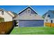 A backyard featuring a blue house, green grass, and wood fence at 1321 Union St, Indianapolis, IN 46225