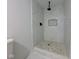 Contemporary bathroom showcasing a walk-in shower with white and marble tiling, complemented by pebble flooring at 1360 N Dearborn St, Indianapolis, IN 46201