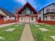 Striking two-story home featuring a modern design, a well-kept lawn, and a charming red-accented porch at 1360 N Dearborn St, Indianapolis, IN 46201