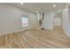 Bright living room with light hardwood floors, staircase, and ample natural light from the large windows at 1360 N Dearborn St, Indianapolis, IN 46201