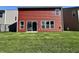 The backyard features a grassy lawn, vinyl siding, and a sliding glass door to access the home at 1380 Delacorte Cir, Shelbyville, IN 46176