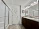 Bathroom showcasing a double sink vanity with a shower and tiled floors, and framed mirrors at 1380 Delacorte Cir, Shelbyville, IN 46176