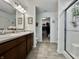 Bathroom with a double sink vanity, framed mirrors, and walk-in shower, plus a walk-in closet at 1380 Delacorte Cir, Shelbyville, IN 46176