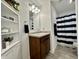 Bathroom features white cabinets, a wooden vanity, and a shower with a striped curtain at 1380 Delacorte Cir, Shelbyville, IN 46176