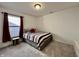 Neutral bedroom with large window featuring carpeted floors and a bed with red accents at 1380 Delacorte Cir, Shelbyville, IN 46176