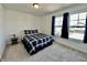 A well lit bedroom with a large window, carpeted floor, and comfortable blue and white bedding at 1380 Delacorte Cir, Shelbyville, IN 46176