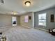 Large bonus room with neutral walls and carpet, and bright windows overlooking the neighborhood at 1380 Delacorte Cir, Shelbyville, IN 46176