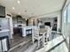 Open concept kitchen with stainless appliances, gray cabinets, dining area, and a view into the living room at 1380 Delacorte Cir, Shelbyville, IN 46176