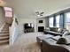 Comfortable living room with neutral decor, a fireplace, large windows, and a staircase leading to the upper level at 1380 Delacorte Cir, Shelbyville, IN 46176