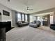 Expansive living room with a fireplace, large windows, neutral decor, and an open layout leading to the kitchen and dining area at 1380 Delacorte Cir, Shelbyville, IN 46176