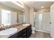 Bathroom features a double sink vanity, large mirror and shower with glass door at 145 Stamford Dr, Pittsboro, IN 46167