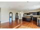 Open-concept kitchen featuring dark cabinets, stainless steel appliances, granite countertops, and hardwood floors at 145 Stamford Dr, Pittsboro, IN 46167