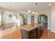 Stylish kitchen island featuring granite countertops, dark cabinets and pendant lighting that opens into the living area at 145 Stamford Dr, Pittsboro, IN 46167