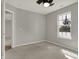 Neutral bedroom showcasing gray walls, carpet, a window with natural light, and a ceiling fan at 14917 Mia Dr, Carmel, IN 46033