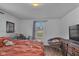 Comfortable bedroom with a window view, a cozy chair, and wood floors at 1504 S Lynhurst Dr, Indianapolis, IN 46241