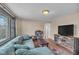 Inviting living room featuring a plush sofa, wood floors, and a large window at 1504 S Lynhurst Dr, Indianapolis, IN 46241