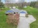 Aerial view of the home featuring a spacious yard, gravel driveway, and mature trees at 1737 W 200 N, Greenfield, IN 46140