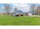 Charming brick and blue home with a well-manicured lawn and inviting curb appeal, nestled among mature trees at 1737 W 200 N, Greenfield, IN 46140