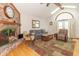 Living room with brick fireplace, hardwood floors, skylights, and comfortable seating with a view to the backyard at 1737 W 200 N, Greenfield, IN 46140