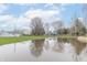 Scenic view of the property featuring a serene pond and a charming blue house in the background at 1737 W 200 N, Greenfield, IN 46140