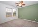 This bedroom features natural light, a ceiling fan, plush carpeting, and a soft green accent wall at 182 Batteese Dr, Cicero, IN 46034