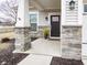 Charming front entrance, featuring decorative stone, mature landscaping, and covered porch at 182 Batteese Dr, Cicero, IN 46034