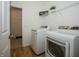 Functional laundry area has modern washer, dryer, built-in shelves, and wood-look flooring at 182 Batteese Dr, Cicero, IN 46034