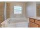 Bathroom with a large soaking tub, tile shower, and a frosted window at 1950 Midnight Pass, Brownsburg, IN 46112