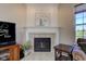 A decorative fireplace with white mantle, tile surround, and floral artwork above at 1950 Midnight Pass, Brownsburg, IN 46112