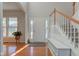 Bright foyer with gleaming hardwood floors, staircase, and a bench with storage at 1950 Midnight Pass, Brownsburg, IN 46112