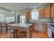 Well-lit kitchen boasts an island with seating, wood cabinets, stainless steel appliances, and a dining area at 1950 Midnight Pass, Brownsburg, IN 46112