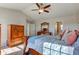 Open-concept bedroom offers carpet flooring, a ceiling fan, and access to ensuite bathroom at 1950 Midnight Pass, Brownsburg, IN 46112