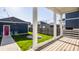 Inviting backyard view from the deck with manicured lawn, string lights, and stylish detached garage with eye-catching red door at 2023 Alvord St, Indianapolis, IN 46202