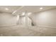 Spacious finished basement with neutral carpet, recessed lighting, and access to the upper floors via staircase at 2023 Alvord St, Indianapolis, IN 46202