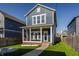 This property has a classic blue exterior with a welcoming front porch and beautifully landscaped front yard at 2023 Alvord St, Indianapolis, IN 46202