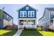 Charming two-story home with a beautiful blue exterior and well-manicured lawn at 2023 Alvord St, Indianapolis, IN 46202