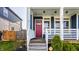 Inviting front porch with a red door, white railings, and lush greenery at 2023 Alvord St, Indianapolis, IN 46202