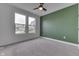 Cozy bedroom with neutral carpet, green accent wall, ceiling fan, and a view of the neighborhood at 2144 Connie Ct, Franklin, IN 46131