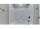 Modern bathtub and shower with white walls, brushed nickel fixtures, and two built-in shelves at 2144 Connie Ct, Franklin, IN 46131