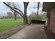 View of backyard, exposed soil, large trees, and house at 2302 W 61St St, Indianapolis, IN 46228