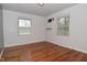 Bedroom with hardwood floors, two windows, and a wall-mounted TV bracket at 2302 W 61St St, Indianapolis, IN 46228