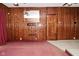 Living room featuring wood paneling, an ornate door, and a mirror, creating a vintage aesthetic at 2302 W 61St St, Indianapolis, IN 46228