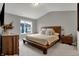 Bright bedroom featuring a minimalist wooden bed frame and a large window with neighborhood views at 3123 Bolton Square Blvd, Indianapolis, IN 46222