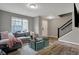 Cozy living room with grey sofa, wood floors, and a staircase, creating a welcoming atmosphere at 3123 Bolton Square Blvd, Indianapolis, IN 46222