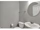 Simple powder room featuring a toilet, sink, and a round mirror at 3123 Bolton Square Blvd, Indianapolis, IN 46222