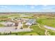 Aerial view showcases a clubhouse, a golf course, and a parking lot amidst a lush green landscape at 3130 Shadow Lake Dr, Indianapolis, IN 46217