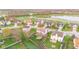 Aerial view of homes featuring fenced backyards with play areas, landscaping, and mature trees near a lake at 3130 Shadow Lake Dr, Indianapolis, IN 46217