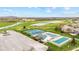 Aerial view showcasing tennis courts and a community pool next to a lush green golf course and ponds at 3130 Shadow Lake Dr, Indianapolis, IN 46217